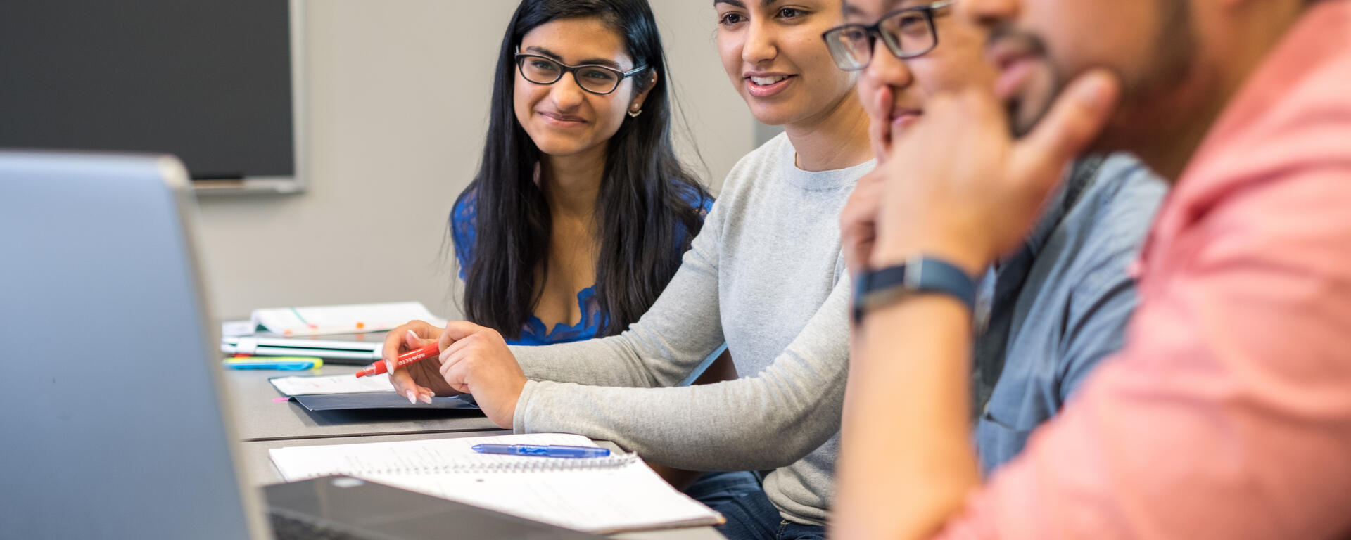four students looking at a screen
