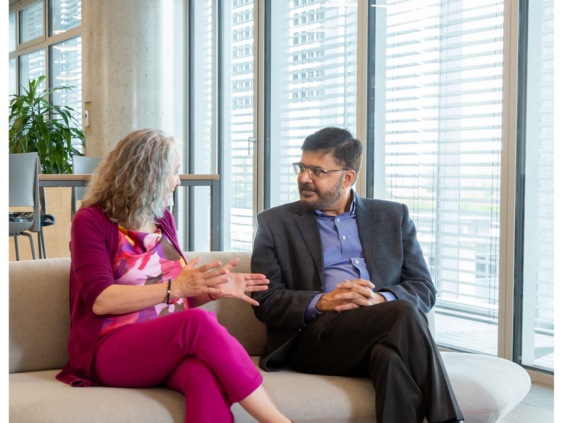 Faculty members chatting on a couch