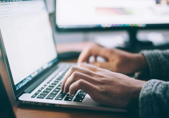 Closeup of hands typing on a laptop